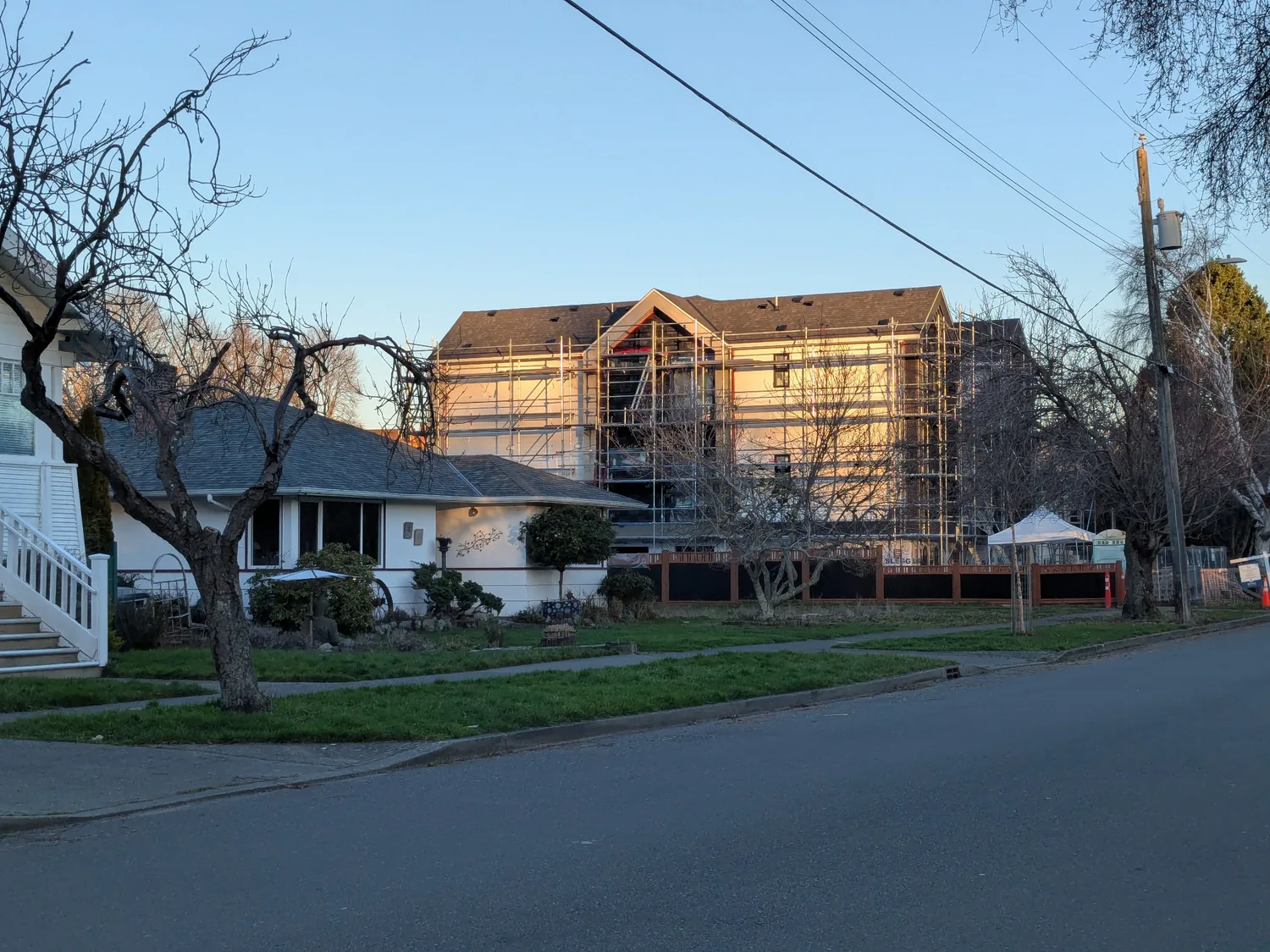 Large building under construction seen from a residential street